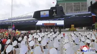 Media pemerintah Korea Utara menggambarkan kapal itu sebagai 'kapal selam serang nuklir taktis' baru. Kim Jong Un menghadiri peluncuran armada tersebut. (STR / KCNA VIA KNS/AFP)