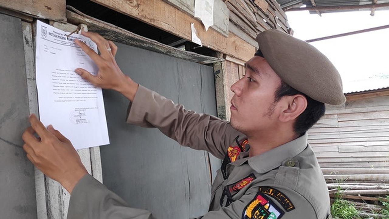 Satpol PP Pekanbaru memasang surat peringatan kepada warung remang-remang yang belum dibongkar pemiliknya.