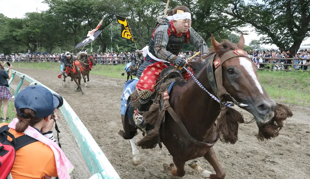 Peserta memacu kudanya saat mengikuti Armor Horse Racing dalam festival Soma Nomaoi di Minamisoma (30/7). Dalam balapan ini peserta mengenakan pakaian dan atribut Samurai yang menjadi ikon tradisional Jepang. (Jun Hirata/Kyodo News via AP)