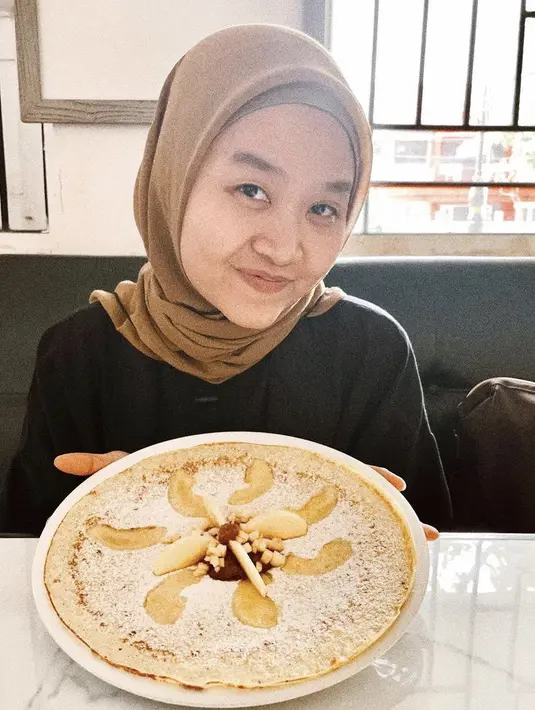 Alca mengenakan kerudung segi empat warna cokelat dengan ciput abu-abunya. Ia memadukannya dengan atasan hitam. @alcaoctvn