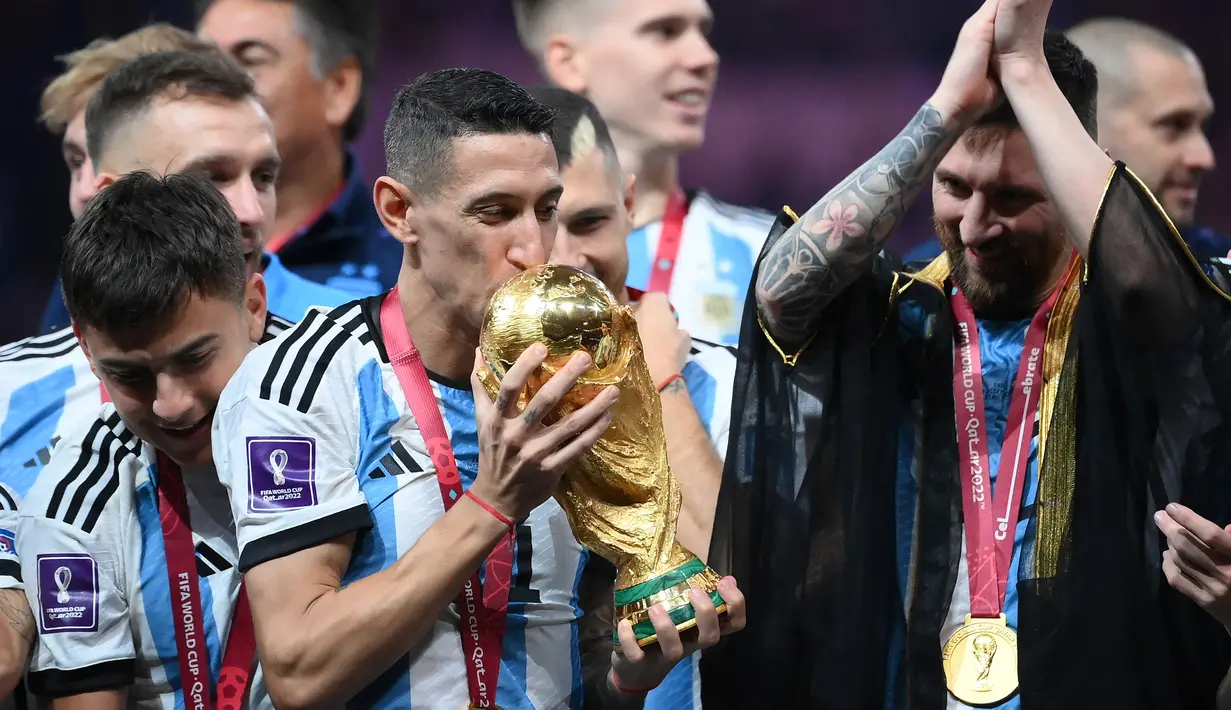 <p>Gelandang Timnas Argentina, Angel Di Maria mencium trofi Piala Dunia dalam perayaan kemenangan usai mengalahkan Prancis pada partai final Piala Dunia 2022 di Lusail Stadium, Doha (18/12/2022). Angel Di Maria direkrut Manchester United pada awal musim 2014/2015 sebagai kerinduan akan sosok Cristiano Ronaldo. Nyatanya ia gagal bersinar bersama MU dan hengkang di musim berikutnya. Bersama PSG dan Juventus ia justru tampil moncer dan akhirnya membawa Argentina menjuarai Piala Dunia 2022. (AFP/Franck Fife)</p>