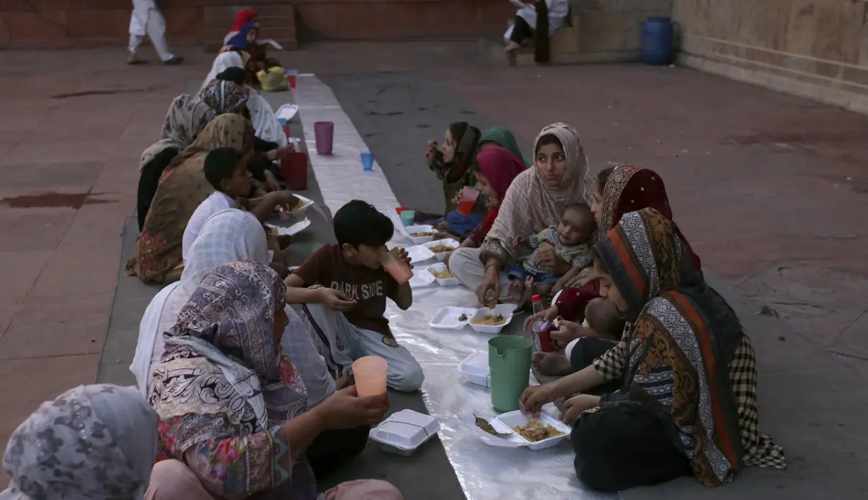 Orang-orang berbuka puasa selama bulan suci Ramadhan di masjid bersejarah Badshahi di Lahore, Pakistan (3/4/2022). Masjid Badshahi merupakan masjid dan sebagai landmark serta tujuan wisata utama kota Lahore. (AP Photo/K.M. Chaudary)