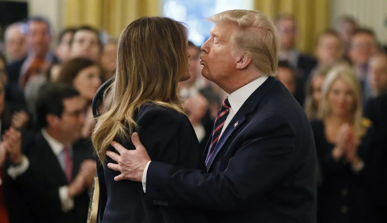 Presiden Donald Trump mencium Ibu Negara Melania Trump di Ruang Timur Gedung Putih di Washington (6/2/2020). Para senator AS memutuskan bahwa Trump tidak bersalah dalam sidang pemakzulan. (AP Photo/Patrick Semansky)