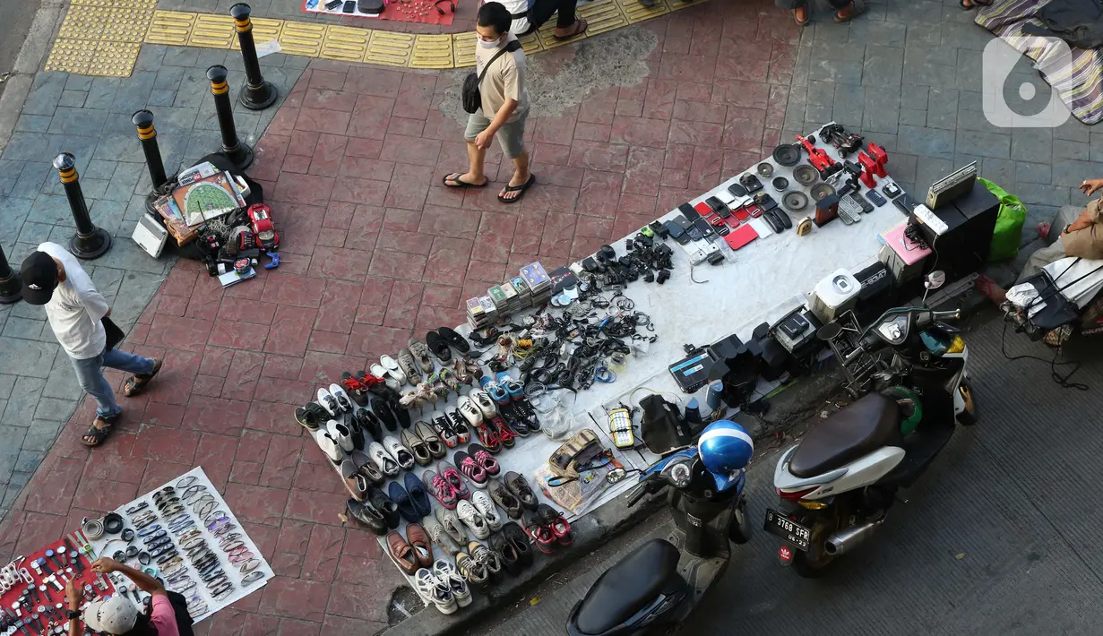 Pedagang kaki lima menjajakan dagangannya di trotoar kawasan Kebayoran Lama, Jakarta, Jumat (15/5/2020). Kondisi ini menyulitkan pejalan kaki yang akan melintasi trotoar di kawasan tersebut. (Liputan6.com/Helmi Fithriansyah)