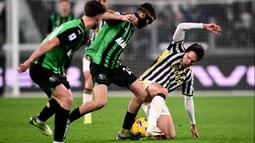 Pemain Juventus, Federico Chiesa, berebut bola dengan pemain Sassuolo, Daniel Boloca, dalam laga Serie A 2023/2024 giornata 20 yang dihelat di Allianz Stadium, Rabu (17/1/2024). (AFP/Marco Bertorello)