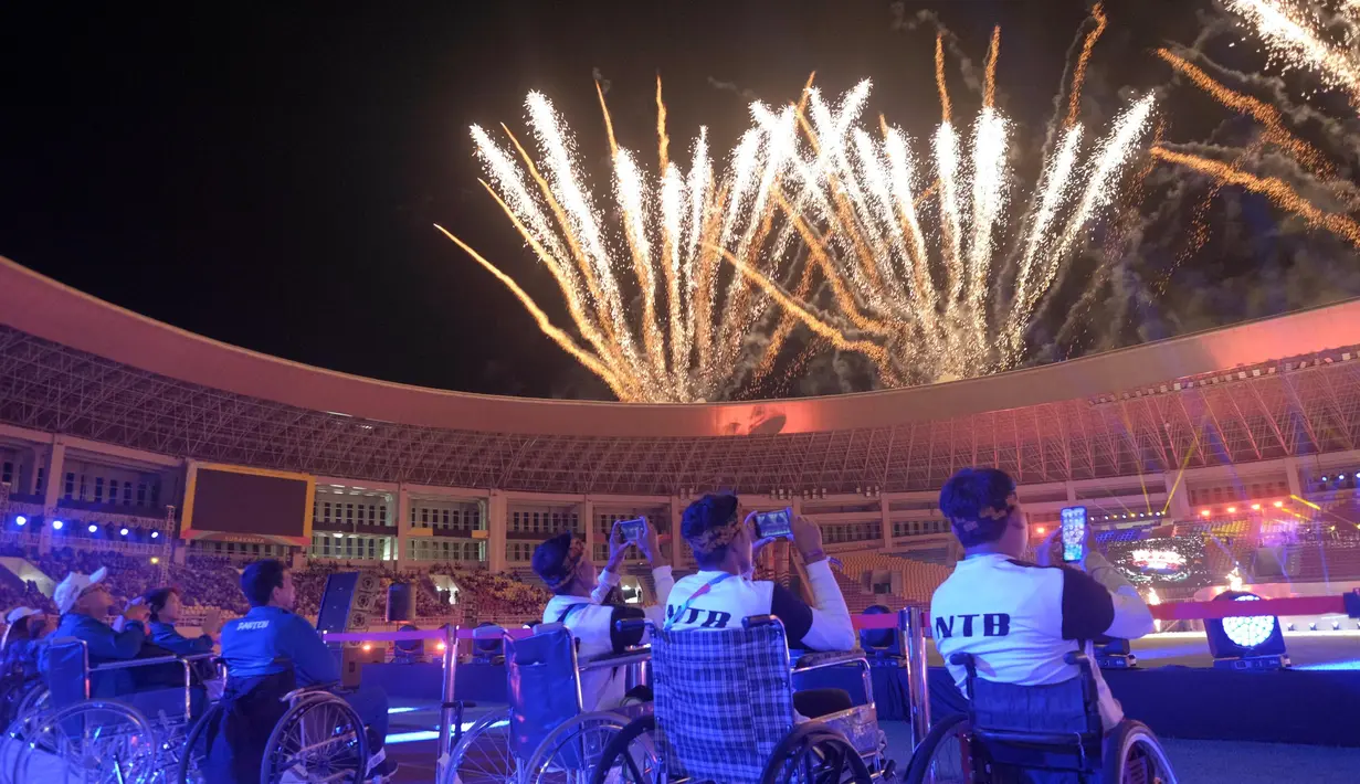Atlet menyaksikan kembang api saat digelar Upacara Pembukaan Pekan Paralimpiade Nasional XVII di Stadion Manahan, Solo, Minggu (6/10/2024). (PB PEPARNAS/Arnold Simanjuntak)
