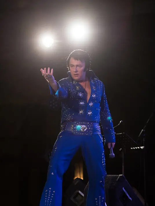 Kontestan yang bernama Gary Graceland bergaya diatas panggung saat mengikuti Kejuaraan Elvis Eropa di Hilton Metropole Hotel di Birmingham, Inggris (5/1). Acara ini diadakan pada akhir pekan ulang tahun Elvis Presley. (AFP Photo/Oli Scarff)