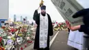 Seorang pendeta Ortodoks memimpin kebaktian di tugu peringatan di depan Balai Kota Crocus di pinggiran utara Moskow, Krasnogorsk, pada 29 Maret 2024. (NATALIA KOLESNIKOVA/AFP)