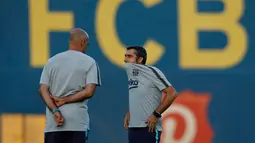Pelatih Barcelona, Ernesto Valverde (kanan) berbincang dengan asistennya selama sesi latihan di Barcelona, Spanyol (17/9). Barcelona akan bertanding melawan PSV Eindhoven pada grup B Liga Champions di Nou Camp. (AP Photo/Manu Fernandez)