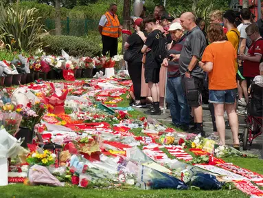 Para simpatisan meninggalkan bunga di tugu peringatan yang didirikan di dekat lapangan sepak bola Anfield untuk penyerang asal Portugal, Diogo Jota, di Liverpool, Inggris, 3 Juli 2025. (Paul BARKER/AFP)