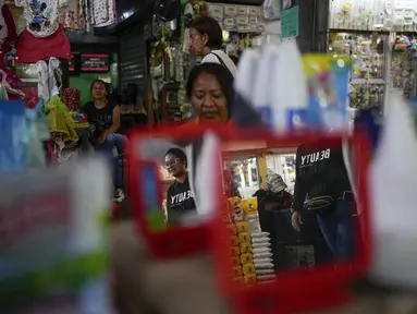 Orang-orang berjalan melalui pasar loak di Maracaibo, Venezuela, Senin, 22 Juli 2024. Venezuela telah mengumumkan akan mengadakan pemilihan presiden pada 28 Juli – beberapa bulan lebih awal dari perkiraan. (AP Photo/Matias Delacroix)