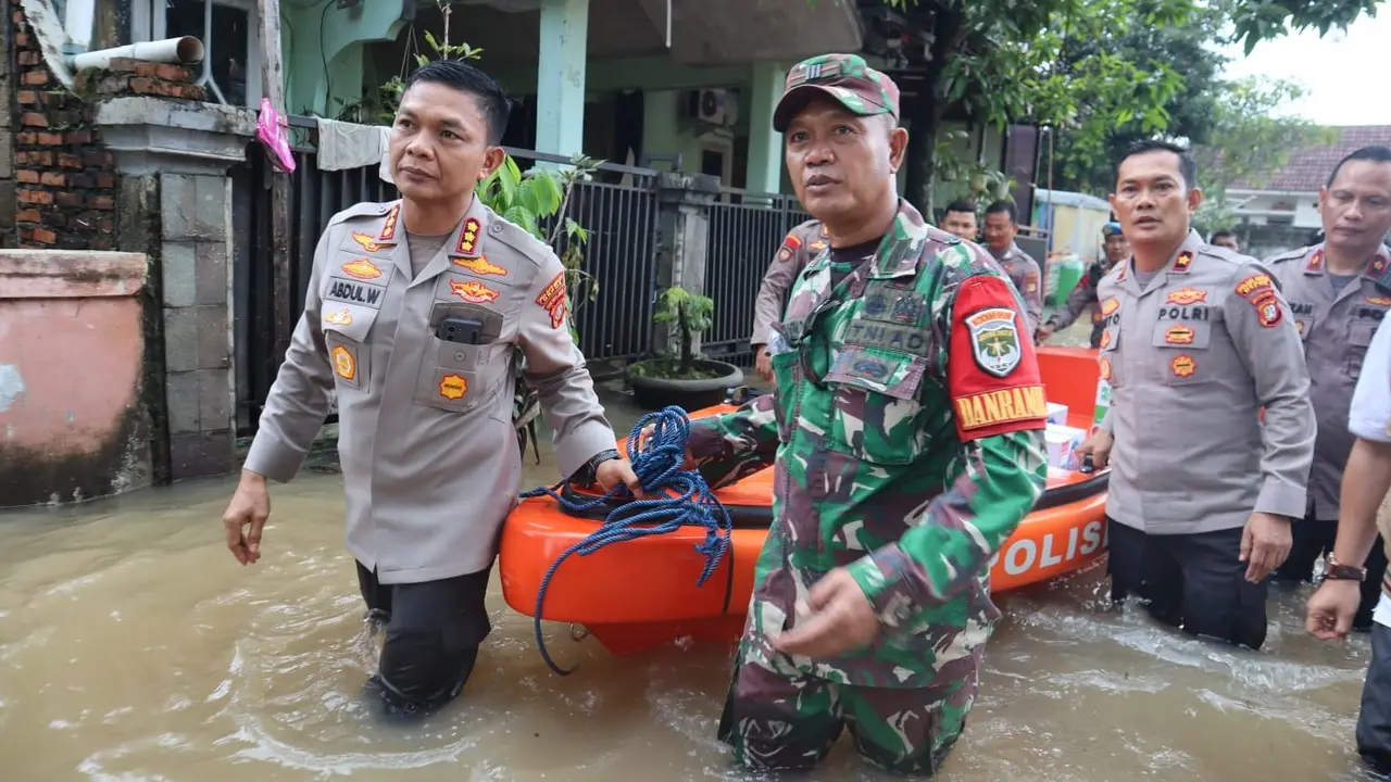 Kapolres Metro Depok, Kombes Abdul Waras membantu mengevakuasi dan memberikan bantuan kepada warga terdampak bajir di Perumahan Sawangan Asri, Sawangan, Depok.
