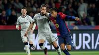 Bek Osasuna asal Spanyol Juan Cruz Alvaro Armada dan penyerang Barcelona asal Spanyol Lamine Yamal berebut bola saat pertandingan sepak bola liga Spanyol antara FC Barcelona dan CA Osasuna di Estadi Olimpic Lluis Companys di Barcelona pada 27 Maret 2025.LLUIS GEN / AFP