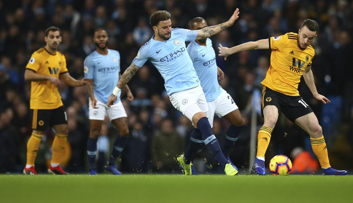 Bek Manchester City, Kyle Walker, berebut bola dengan pemain Wolverhampton Wanderers, Diogo Jota, pada laga Premier League di Stadion Etihad, Manchester, Senin (14/1). Manchester City menang 3-0 atas Wolverhampton Wanderers. (AP/Dave Thompson)