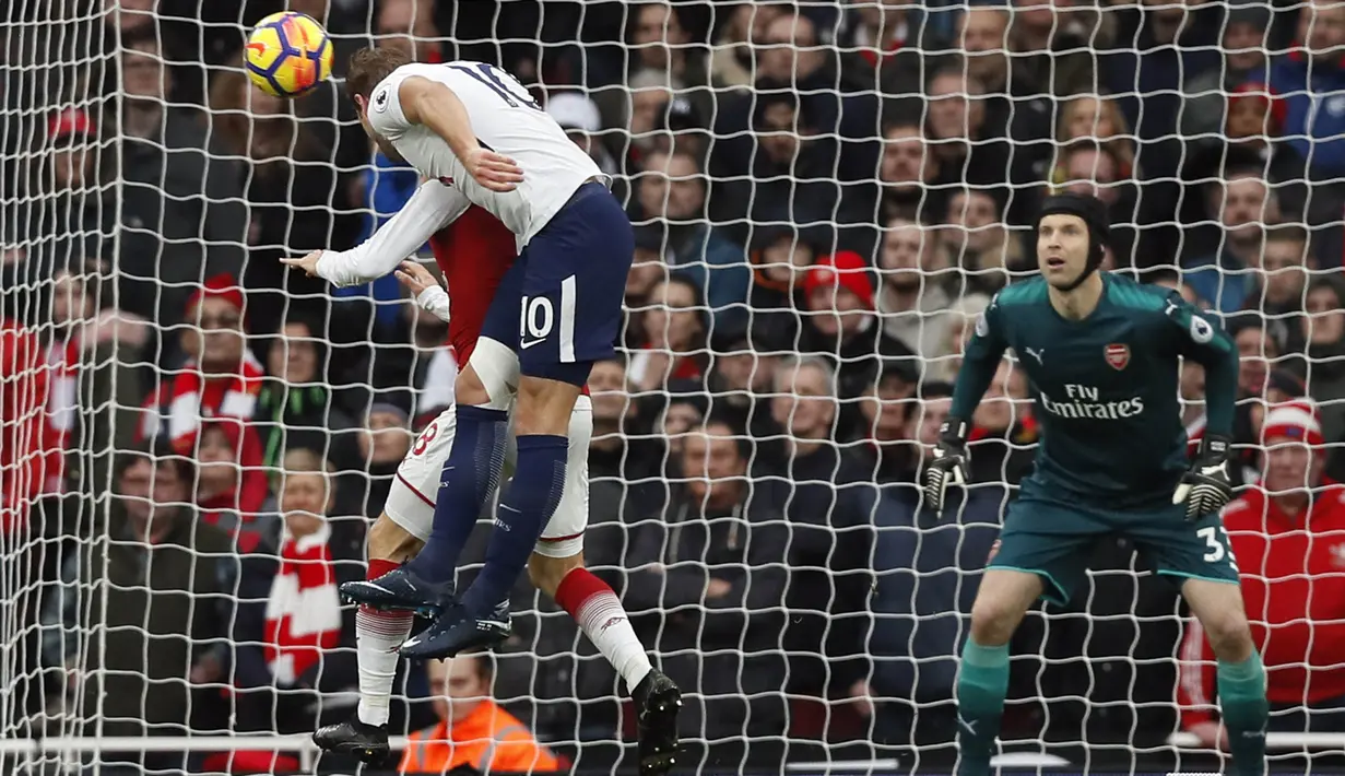 Striker Tottenham, Harry Kane, melepas sundulan ke gawang Arsenal yang dijaga Petr Cech pada laga Premier League di Stadion Emirates, London, Sabtu (18/11/2017). Arsenal menang 2-0 atas Tottenham. (AP/Kirsty Wigglesworth)
