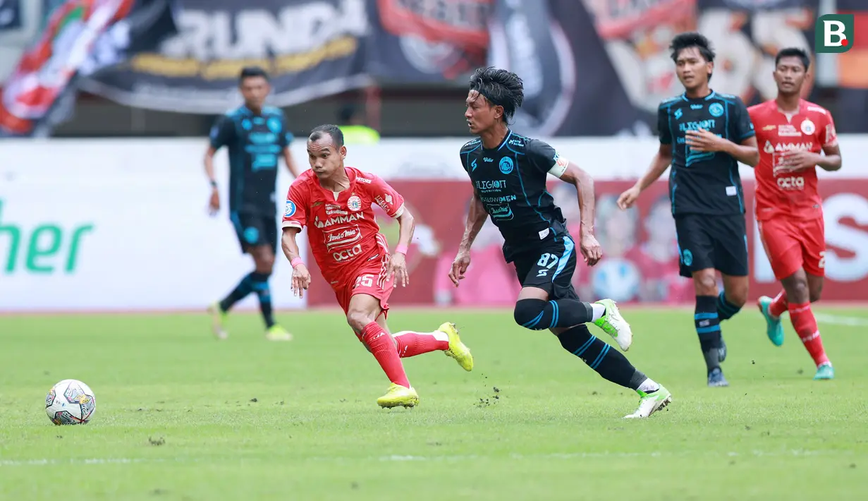 Pemain Persija Jakarta, Riko Simanjuntak berebut bola dengan pemain Arema FC, Johan Ahmad Alfarizi dalam laga pekan ke-23 BRI Liga 1 2022/2023 di Stadion Patriot Candrabhaga, Bekasi, Minggu (12/2/2023) sore WIB. Persija menang dengan skor 2-0. (Bola.com/M Iqbal Ichsan)