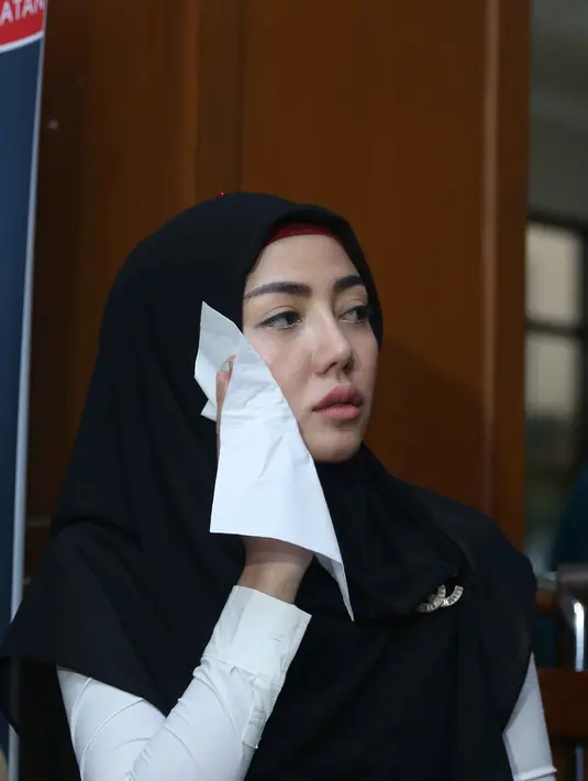 Dengan mengenakan kerudung hitam, serta setelan busana atas bawah putih panjang. (Nurwahyunan/Bintang.com)