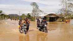 Pengendara sepeda motor melintasi jalan raya yang banjir usai terjangan topan Phanfone di Ormoc City, Provinsi Leyte, Filipina, Rabu (25/12/2019). Topan membuat jutaan warga di negara yang mayoritas beragama Katolik itu merayakan Natal dengan kesedihan. (RONALD FRANK DEJON/AFP)