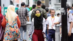 Warga berjalan di pedestrian di kawasan Jalan Jenderal Sudirman, Jakarta, Jumat (14/7). Kepala Dinas LHK DKI Jakarta Isnawa Adji menjelaskan pihaknya terus berupaya melakukan pemantauan kualitas udara secara berkala. (Liputan6.com/Helmi Fithriansyah)