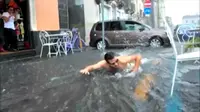 Daripada mengeluhkan banjir, pria Italia ini memutuskan untuk menggunakan saat banjir untuk menghibur diri dengan berenang.