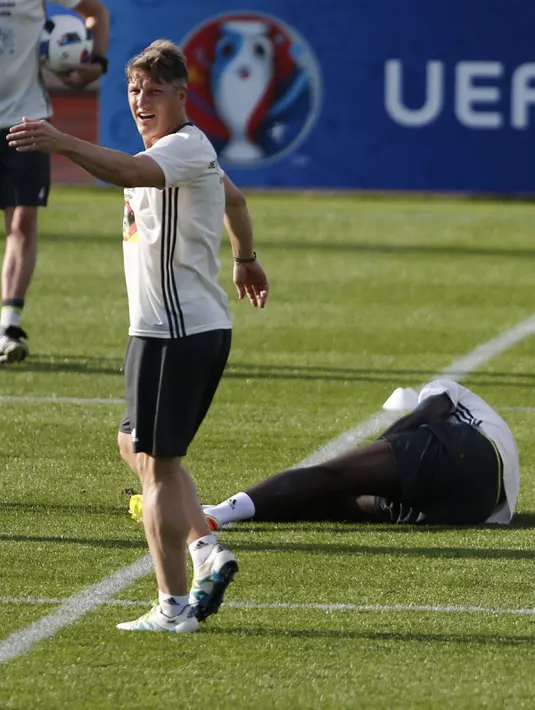 Gelandang Jerman, Bastian Schweinsteiger saat memanggil tim medis untuk rekan setimnya Jerome Boateng yang terkapar di Stade Camille Fournier, Perancis, (7/6). (REUTERS / Denis Balibouse)