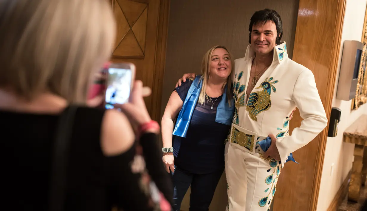 Kontestan asal Belanda, Casper Slee berpose untuk difoto bersama penggemar setelah mengikuti Kejuaraan Elvis Eropa di Hilton Metropole Hotel di Birmingham, Inggris (5/1). (AFP Photo/Oli Scarff)