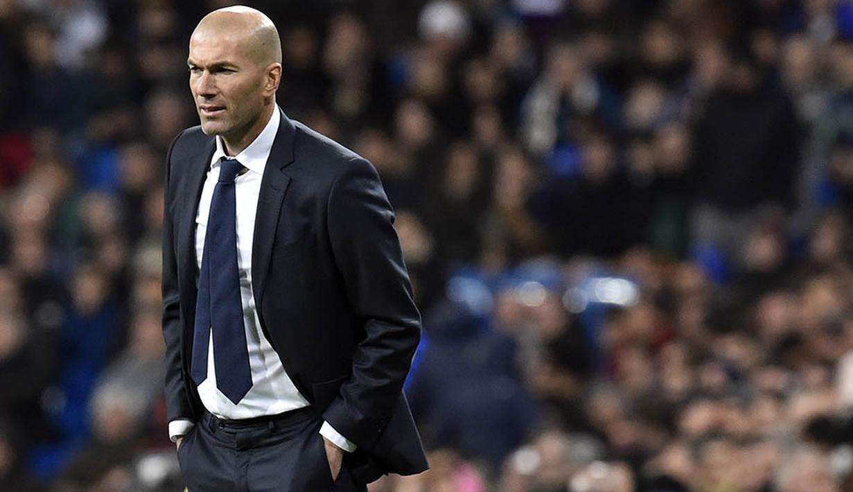 Pelatih baru Real Madrid, Zinedine Zidane, mengamati permainan anak asuhnya saat melawan Deportivo pada laga La Liga Spanyol. Debut Zidane berjalan manis dengan kemenangan telak. (AFP/Gerard Julien)
