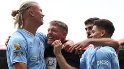 Erling Haaland pun sempat memeluk pitch invader yang bernama Terry Flanagan. Terry bukan merupakan sembarang fans. Ia merupakan seorang mantan petinju kelahiran Manchester dan pernah menjadi juara dunia. (AFP/Darren Staples)