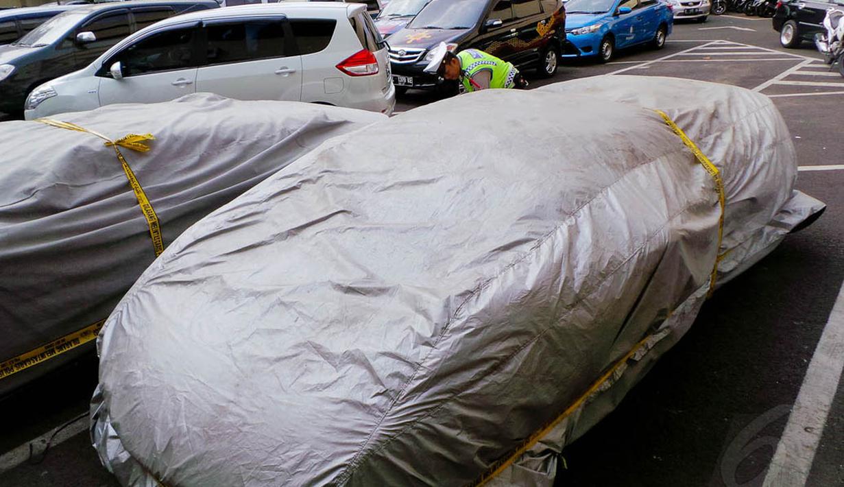 Di Gedung Korlantas Polri, mobil warna hijau tersebut ditutup dengan penutup mobil warna silver, Jakarta, (1/9/14). (Liputan6.com/Faizal Fanani)