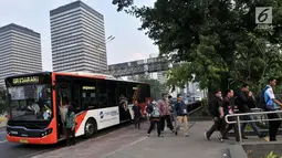 Penumpang turun dari bus Transjakarta di Kawasan Terintegrasi Transportasi Dukuh Atas, Jakarta, Rabu (12/6/2019). PT Transjakarta mencatat adanya peningkatan penumpang setelah Moda Raya Terpadu (MRT) beroperasi. (merdeka.com/Iqbal S. Nugroho)