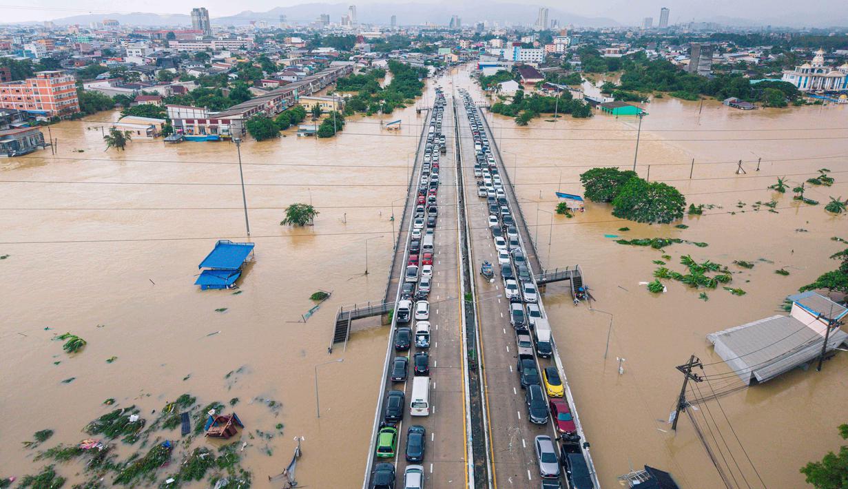 Banjir dipicu hujan lebat yang disebut sebagai yang terbesar dalam 300 tahun terakhir. Tampak dalam foto, mobil dan rumah terendam banjir di Provinsi Songkhla, Thailand selatan, Rabu 26 November 2025. (AP Photo/Arnun Chonmahatrakool)