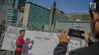 Masyarakat menandatangani dilukisan capres 01 dan 02  yang bertema ‘ Pemilu Penuh Cinta’  saat Car Free day di kawasan Bundaran HI, Jakarta, MInggu (14/4). Kampanye tersebut untuk mengajak masyarakat untuk berpartisipasi dalam Pemilu secara Damai. (Liputan6.com/Faizal Fanani)