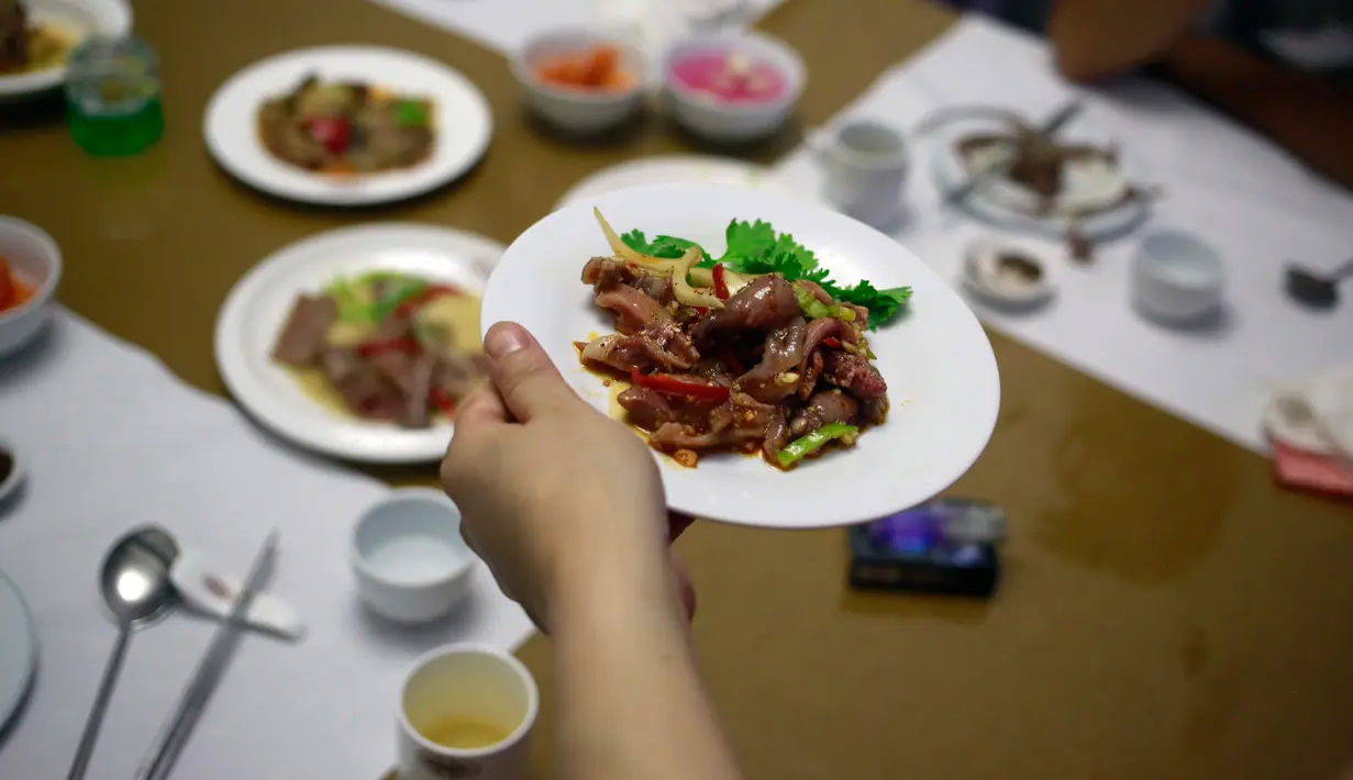 <p>Pramusaji menyajikan hidang dari daging anjing di restoran khusus anjing, Pyongyang House of Sweet Meat, di Korea Utara, Rabu (25/7). Dikenal dengan nama dangogi, daging anjing banyak dikonsumsi oleh masyarakat Korea saat cuaca panas. (AP/Dita Alangkara)</p>