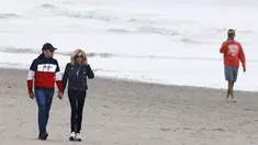 Presiden Prancis Emmanuel Macron dan istrinya Brigitte Macron berjalan di sepanjang pantai di Le Touquet, menjelang putaran kedua pemilihan presiden Prancis, Sabtu (23/4/2022). Emmanuel Macron akan menghadapi Marine Le Pen dalam putaran kedua pemilihan presiden (pilpres) pada 24 April 2022. (Ludovic MARIN / AFP)