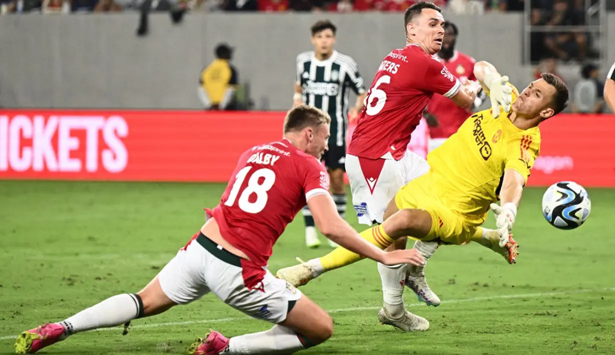 Pemain Wrexham Sam Dalby (kiri) mencetak gol ke gawag Manchester United pada pertandingan sepak bola persahabatan pramusim di Stadion Snapdragon, San Diego, California, Amerika Serikat, 25 Juli 2023. (Patrick T. Fallon/AFP)