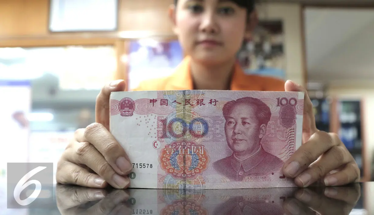 <p>Seorang teller menunjukan mata uang Yuan di Jakarta, Senin (30/11). Dana Moneter Internasional (IMF), Senin (30/11), resmi memasukan yuan, atau renminbi, ke dalam special drawing rights (SDR) sebagai mata uang elite dunia. (Liputan6.com/Angga Yuniar)</p>