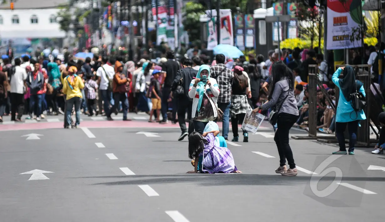 Sejumlah warga memanfaatkan moment untuk selfie di Jalan Asia Afrika, Bandung yang sedang disterilkan dari kendaraan bermotor untuk puncak perayaan ke-60 Konferensi Asia Afrika, Jumat (24/2015). (Liputan6.com/Faizal Fanani)