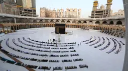 Suasana Hari Raya Idul Fitri di Berbagai Negara: Jemaah melaksanakan salat Idul Fitri di Masjidil Haram, Mekah, Arab Saudi, Minggu (24/5/2020). Salat Idul Fitri tetap digelar di Masjidil Haram dan Masjid Nabawi namun dengan jemaah terbatas. (AFP)