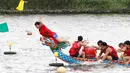 Seorang kapten berhasil meraih bendera usai mencapai garis finish perlombaan tradisional China, Dragon Boat di Taipei, Taiwan, Minggu (28/5). Perlombaan ini untuk mengenang kematian penyair Qu Yuan yang tenggelam pada 278 SM. (AP Photo/Chiang Ying-ying)