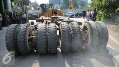 Warga melihat truk bermuatan alat berat ekskavator mengalami patah as di Jakarta, Selasa (29/9/2015). Imbas dari truk bermuatan alat berat mengalami patah as itu, Jalan Sudirman mengarah ke Jalan MH Thamrin terpantau padat. (Liputan6.com/Gempur M Surya)