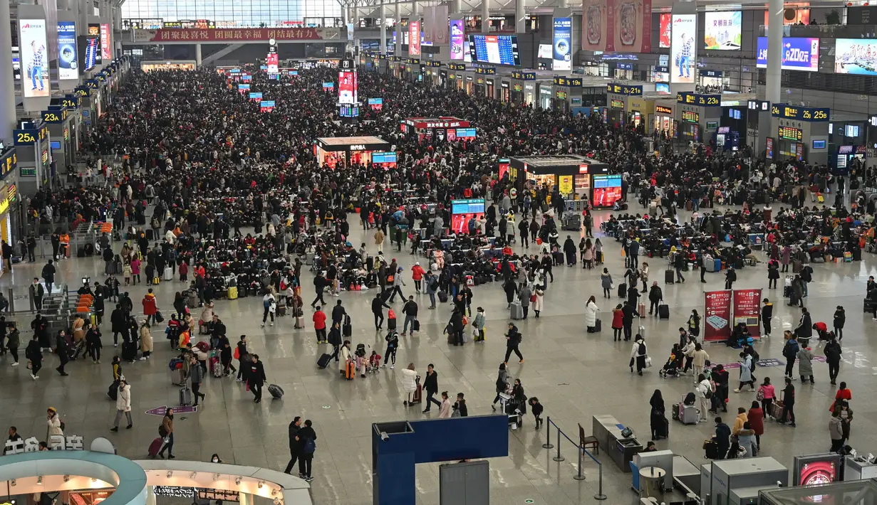 Padatnya Arus Mudik ala China: Penumpang menunggu jadwal keberangkatan mereka di Stasiun Kereta Hongqiao di Shanghai pada Senin (20/1/2020). China berada di tengah-tengah kesibukan migrasi manusia tahunan ketika jutaan orang pulang ke kampung halaman untuk menikmati libur Imlek. (HECTOR RETAMAL/AFP)
