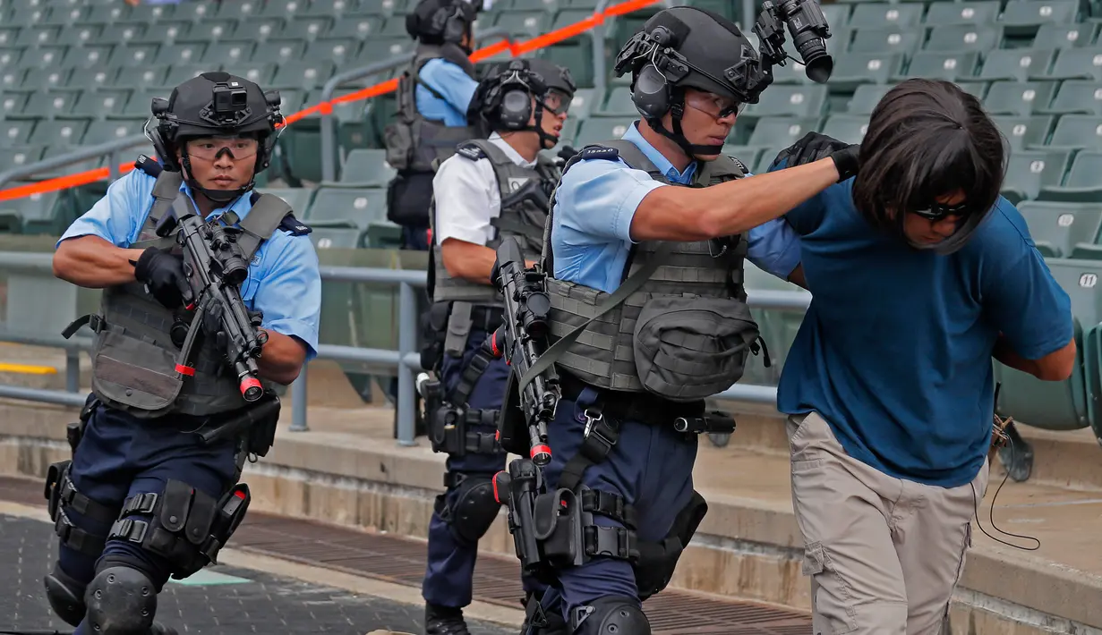 Petugas polisi menolong korban saat latihan anti-teror di Hong Kong, Jumat, (25/8). Simulasi serangan anti-teror ini untuk persiapan sebuah konser penyanyi Ariana Grande pada 21 September 2017. (AP Photo / Vincent Yu)