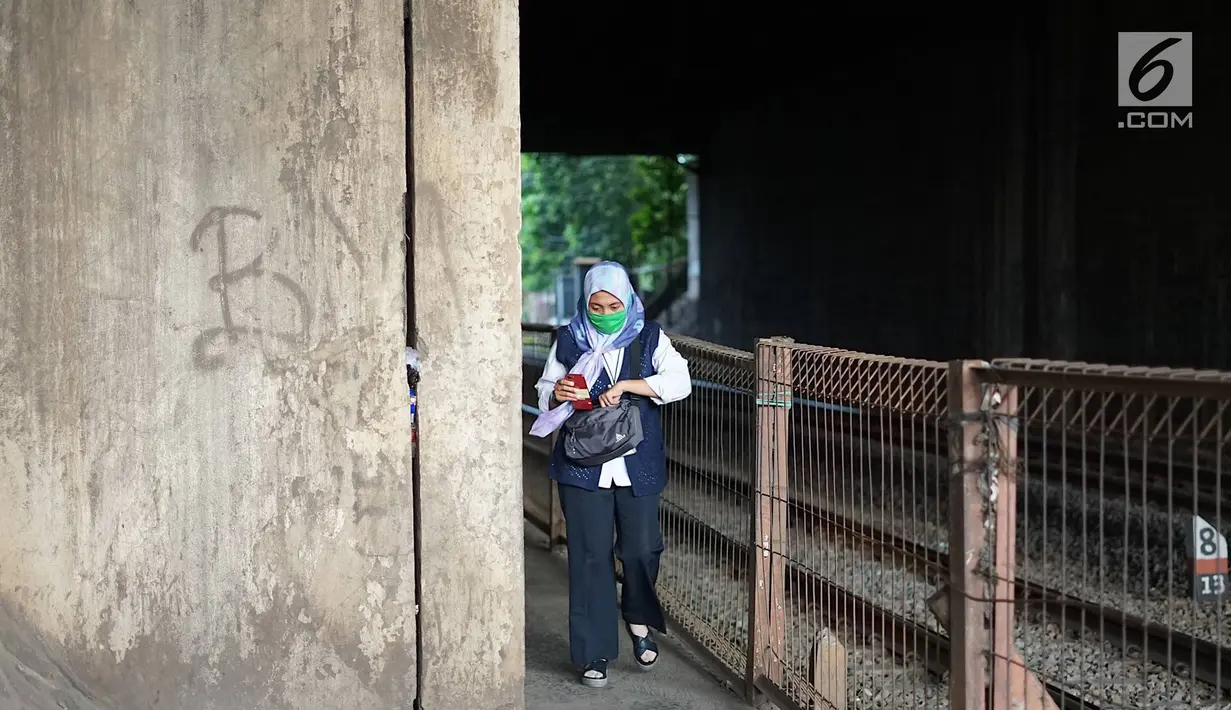 Pejalan kaki melintasi jalan setapak di sekitar Stasiun Cawang, Jakarta, Kamis (9/5). Meskipun sempit, jalan setapak tersebut masih menjadi pilihan sebagian pejalan kaki untuk menyeberangi Jalan Gatot Soebroto, dibanding harus melewati JPO yang jaraknya lebih jauh. (Liputan6.com/Immanuel Antonius)