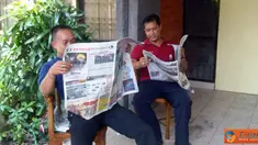 Citizen6, Bali: Pada Minggu, 10 April 2011 di Jalan PB Sudirman, Kampus Udayana. Yudiartwan (24) dan Komang Jaunuadi (37) mengisi waktu di sela-sela waktu kerja dengan membaca koran, agar tidak bosan dan juga menambah informasi. (Pengirim: Kelompok 11) 