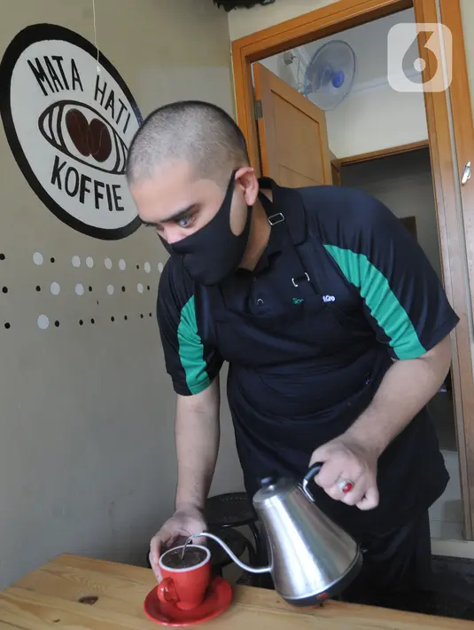 Ahmad Hilmy Almusawa, pemuda 22 tahun penyandang tunanetra menyediakan kopi untuk pelanggan di Mata Hati Koffie di Jalan Cabe, Pondok Cabe Ilir, Pamulang, Tangerang Selatan, Banten, Selasa (21/7/2020). (merdeka.com/Arie Basuki)