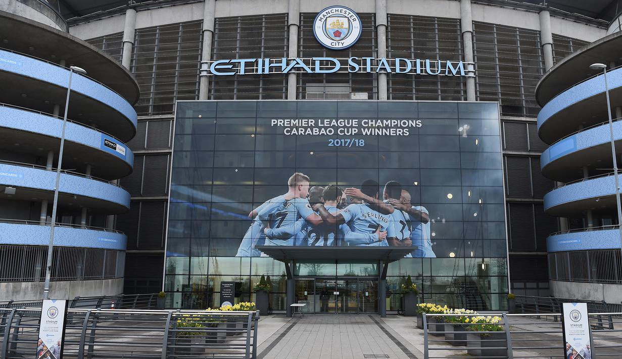 Poster raksasa bergambar pemain Manchester City terpasang di Stadion Etihad, Manchester, Senin (17/4/2018). Persiapan ini dilakukan untuk merayakan pesta juara Manchester City meraih gelar Premier League. (AFP/Paul Ellis)