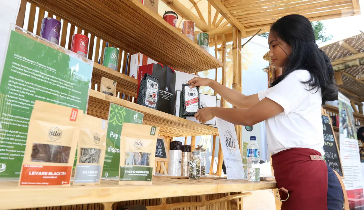 SPG merapikan produk Teh Sila dan Kopi Rollaas milik Holding Perkebunan Nusantara (PTPN Group) yang dipamerkan Indonesia Pavilion saat  IMF-World Bank 2018, Nusa Dua, Bali, Kamis (11/10). (Liputan6.com/Angga Yuniar)