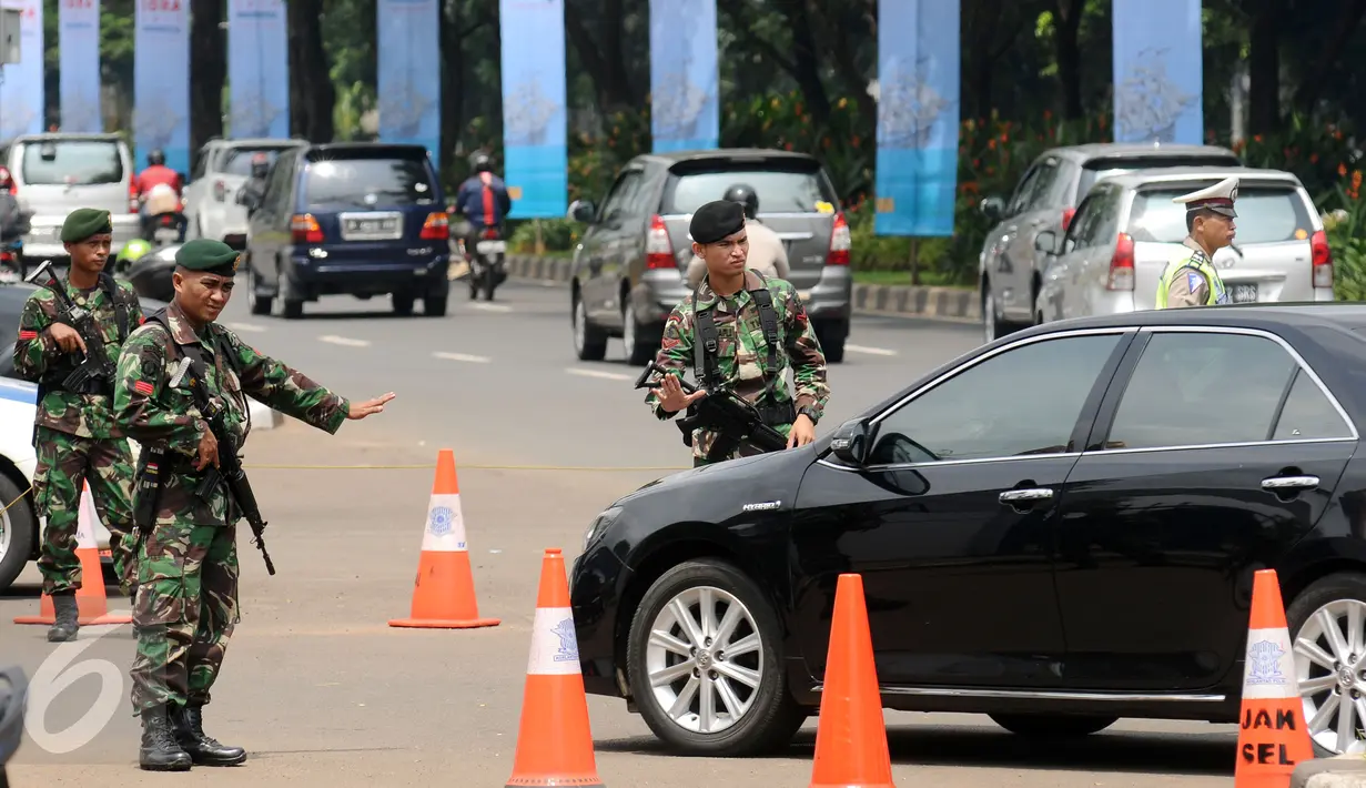 Personel TNI bersenjata lengkap menyetop kendaraan yang akan masuk kawasan Gelora Bung Karno, Jakarta, Senin (6/3). Pengamanan ini terkait pelaksanaan KTT IORA 2017 yang digelar di Jakarta Convention Center 5-7 Maret. (Liputan6.com/Helmi Fithriansyah)