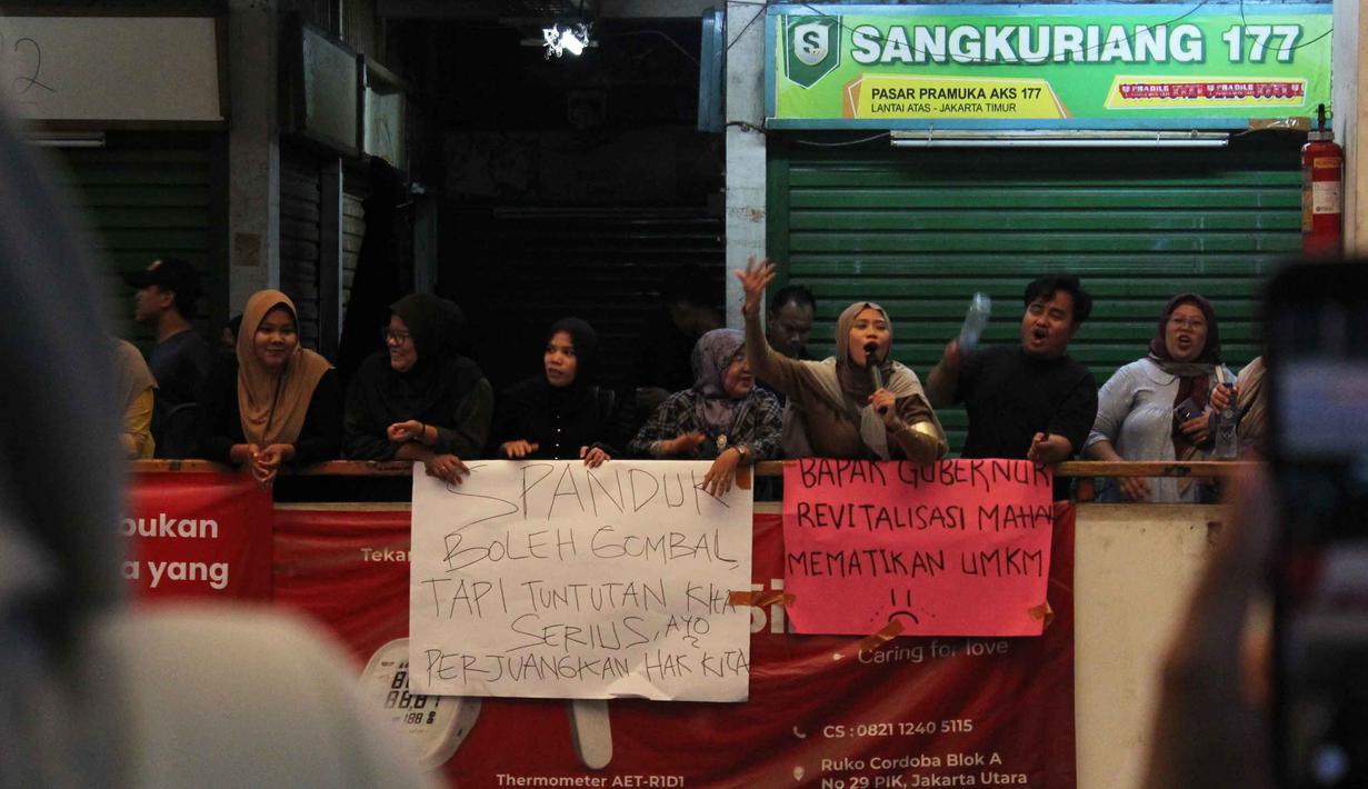 Para pedagang keberatan dengan kenaikan harga sewa kios yang dinilai terlalu tinggi, bahkan mencapai empat kali lipat setelah revitalisasi. Tampak dalam foto, para pedagang melakukan aksi protes di dalam Pasar Pramuka, Jakarta Timur, Jumat (14/11/2025). (merdeka.com/magang/Rendi Saputra)