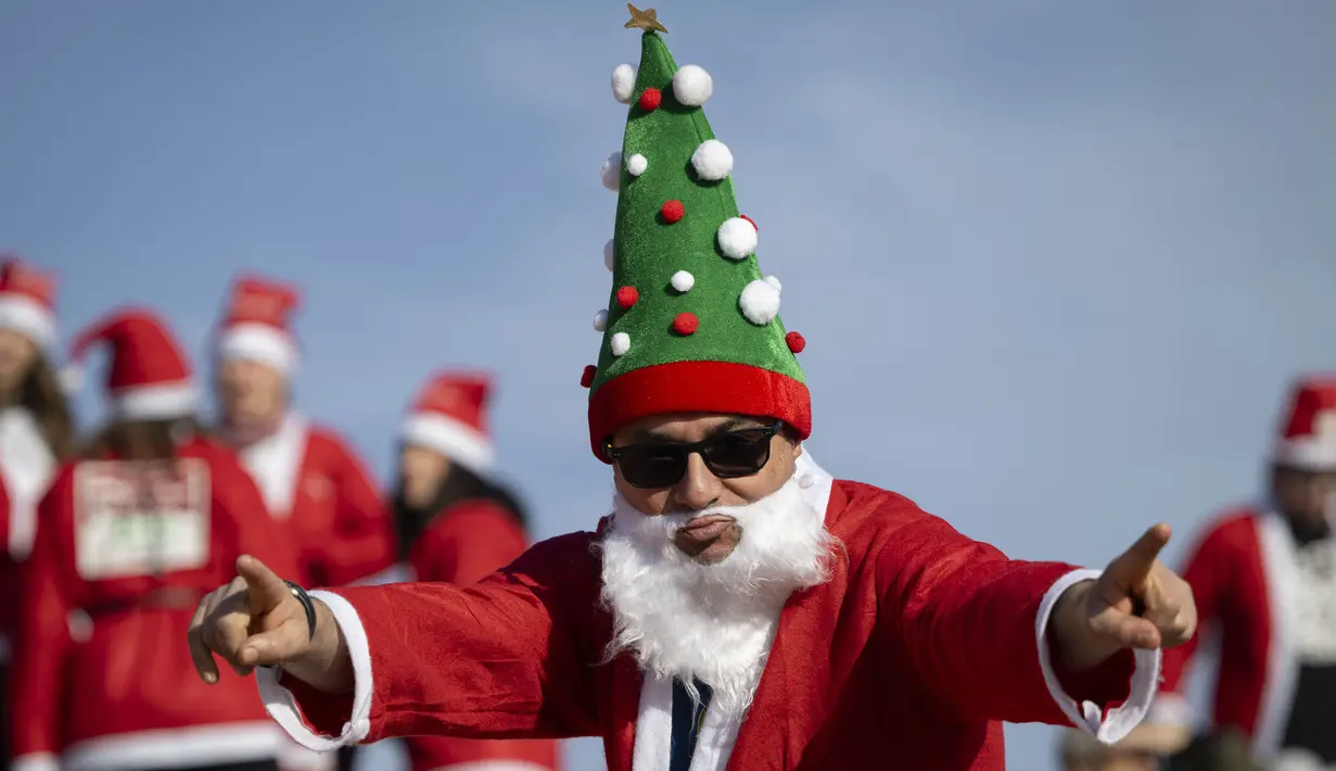 Seorang pelari berkostum Sinterklas berpose saat bersiap dalam acara fun run 5 km pada Minggu (22/12/2024) waktu setempat. (AFP/Josep Lago)